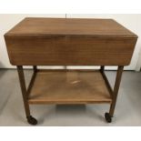 A vintage wooden drop leaf tea trolley with under shelf.