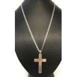 A large silver cross pendant on a 22" curb chain.