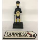 A painted cast iron Guinness advertising money bank together with a wall hanging plaque.