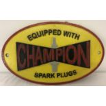 A painted cast iron Champion spark plugs, oval shaped wall hanging plaque.