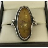 A white metal amber set Art Nouveau style dress ring.