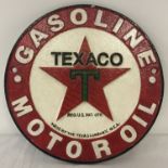 A circular shaped painted cast metal, Texaco motor Oil, wall hanging plaque.