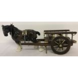 A large ceramic shire horse together with a wooden cart.