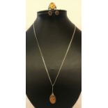 3 items of amber jewellery. A unusual design locket on a curb chain, a pair of oval stud earrings