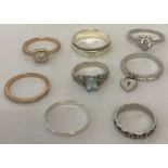 A collection of 8 silver and white metal dress rings.