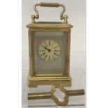 A miniature brass carriage clock with hand painted ceramic panels and bevel edged glass.
