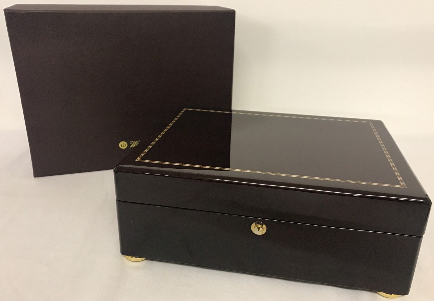 A new large boxed mahogany jewellery box by Walwood with inlaid detail to lid and brass bun feet.