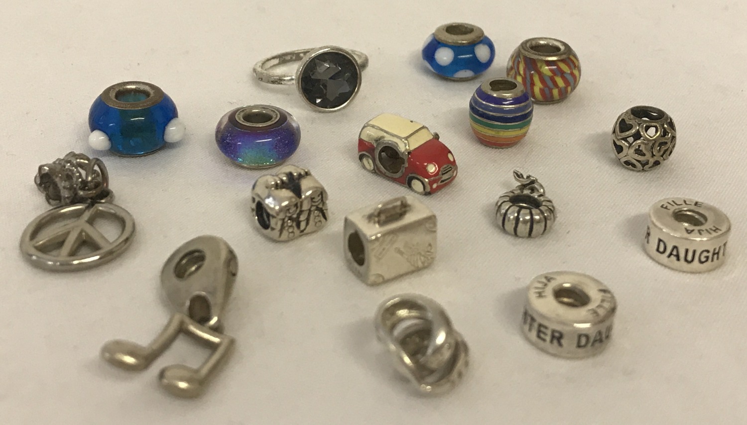 A collection of silver and white metal charm beads.