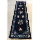 A deep pile oriental pattern hall runner rug. Blue ground with pink and green floral decoration.