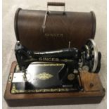 A vintage wooden cased Singer sewing machine with gilt decoration, complete with key.