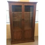 A modern, heavy, solid oak glass fronted 2 door display cabinet.