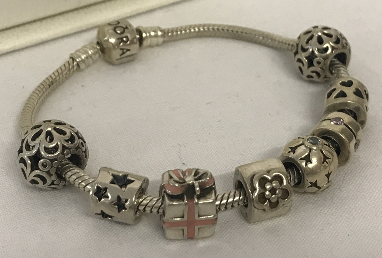 A 925 silver Pandora charm bracelet with 8 charms. Complete with original bracelet box.