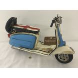 A modern painted tin plate ornament of a Lambretta type scooter.