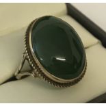 A 9ct gold dress ring set with an oval cut cabochon jade stone.