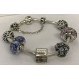 A 925 silver Pandora bracelet and 7 charms. Complete with original bracelet box.