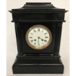 A Victorian black slate mantle clock with column detail.