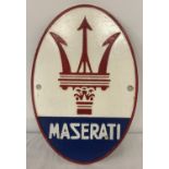 An oval shaped painted cast metal, wall hanging Maserati plaque.