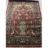 A red ground vintage Persian style rug decorated with floral and bird design.