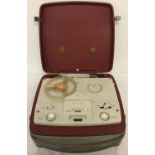 A vintage BSR portable reel to reel recorder in maroon and cream case.