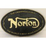 A painted cast iron, wall hanging oval shaped sign for Norton.