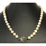 A string of freshwater pearls with decorative clasp with cut out heart detail to underside of clasp.