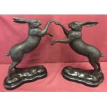 A pair of bronze "boxing hares" figurines mounted on marble bases.