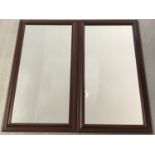A pair of modern framed wall mirrors with brown wood effect frames.