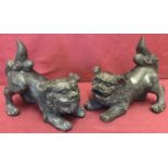 A pair of Chinese hollow bronze Foo dog figures.