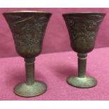 2 small Chinese bronze stemmed goblets with dragon design to outer bowl.