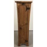 A slim line pine cupboard with fish tail style hinges to front door.
