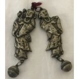 A pair of Chinese white metal rattle bells with hollow figural detail.