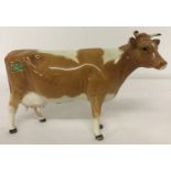 A Beswick Guernsey cow, Model #1248A. With separate horns & ears and green Beswick label.