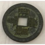 A Chinese bronze coin/medallion with square shaped cut-out to centre.
