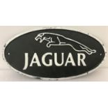 A painted cast iron oval shaped wall hanging sign for Jaguar.