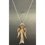 A silver and amber set pendant in the shape of an angel, on an 18" fine curb chain.