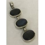 A modern design drop silver pendant set with 3 oval cut labradorite stones.