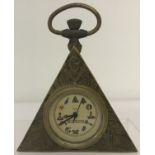 A small brass cased, triangular shaped pocket watch with Masonic style decoration.