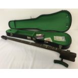 A vintage green felt lined violin case together with a stringed instrument with leg rests.