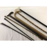 A collection of assorted riding crops and walking sticks.