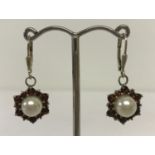 A pair of faux pearl and garnet drop earrings.