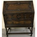 A vintage dark wood bureau with interior stationery compartments.