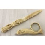 Bone decorative handled letter opener together with a bone magnifying glass shaped like a dolphin.