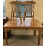 A pine kitchen table with turned legs together with 2 farmhouse pine kitchen chairs.