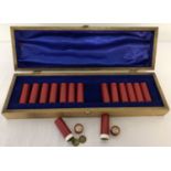 A wooden box containing 15 tubes of vintage threepences.