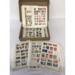 A box of assorted sheets of vintage foreign stamps.