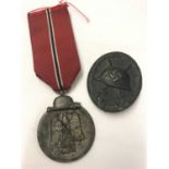 A German WWII style Eastern front medal and ribbon together with a black wound badge.