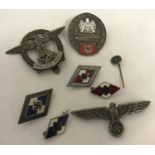 A collection of WWII style German military badges and lapel pins.