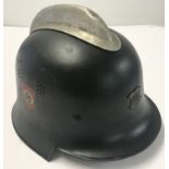 A WWII style German Fireman's helmet with badge and hand painted decals.