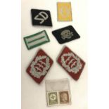 A small collection of German military style cloth badges together with 2 Adolph Hitler stamps.