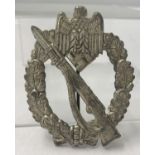 A German WWII style pinback Infantry Assault badge.